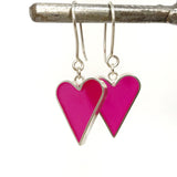 Pink heart-shaped earrings on a white background